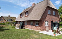 Reetdach gedecktes Friesenhaus mit Klinkerbau Fassade